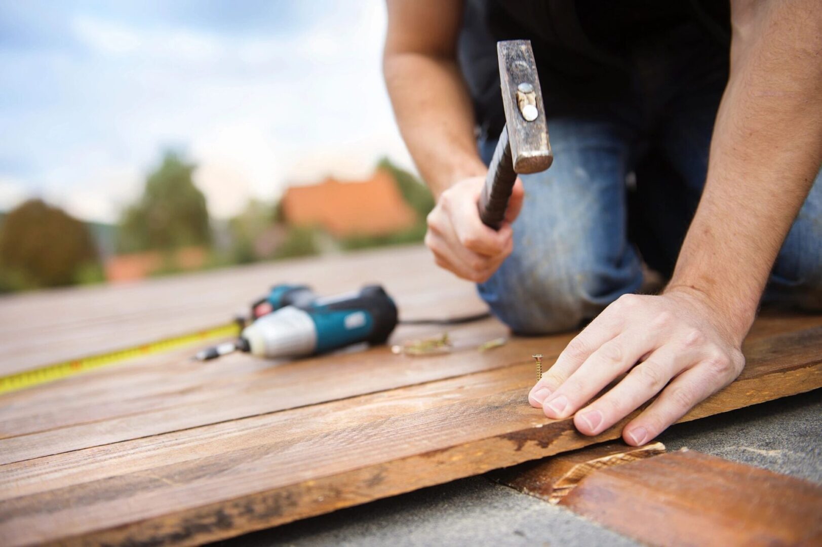 Close-up of hands hammering wooden deck