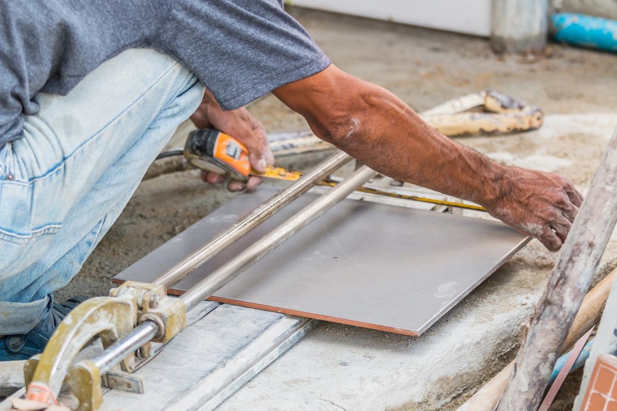 Worker cutting ceramic tile with manual cutter