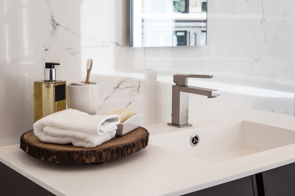 Modern bathroom sink with wooden tray, toiletries