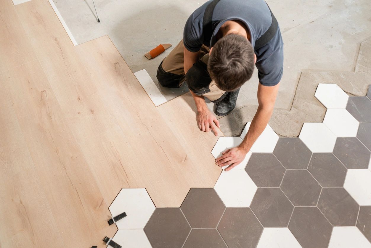 Worker installing hexagonal black and white floor tiles