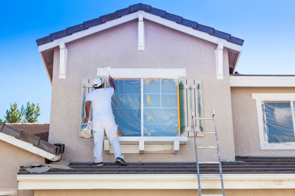 Exterior house painter painting window trim