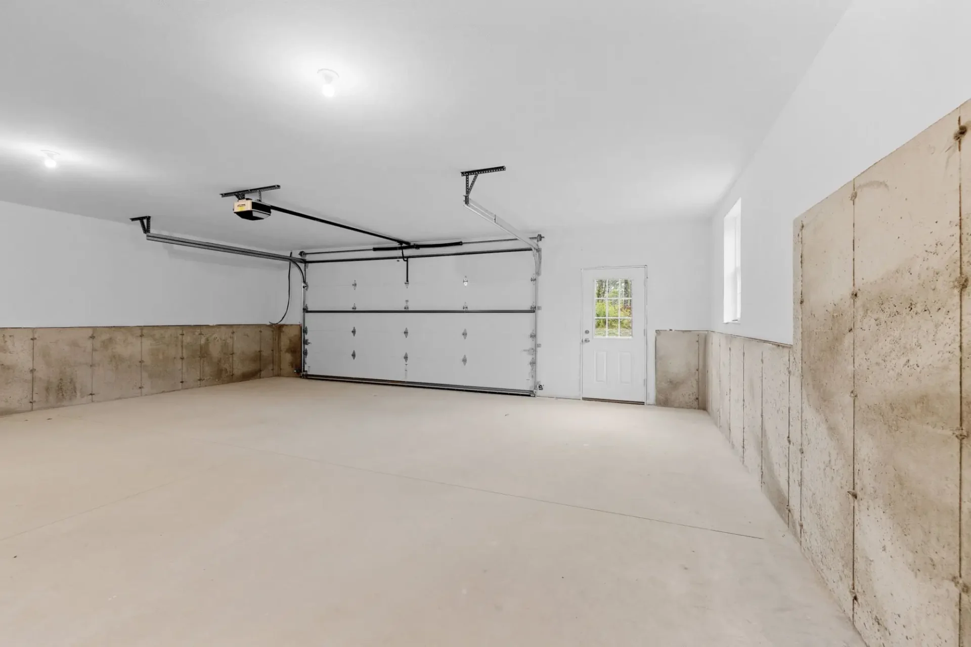 Spacious empty two-car garage with side door