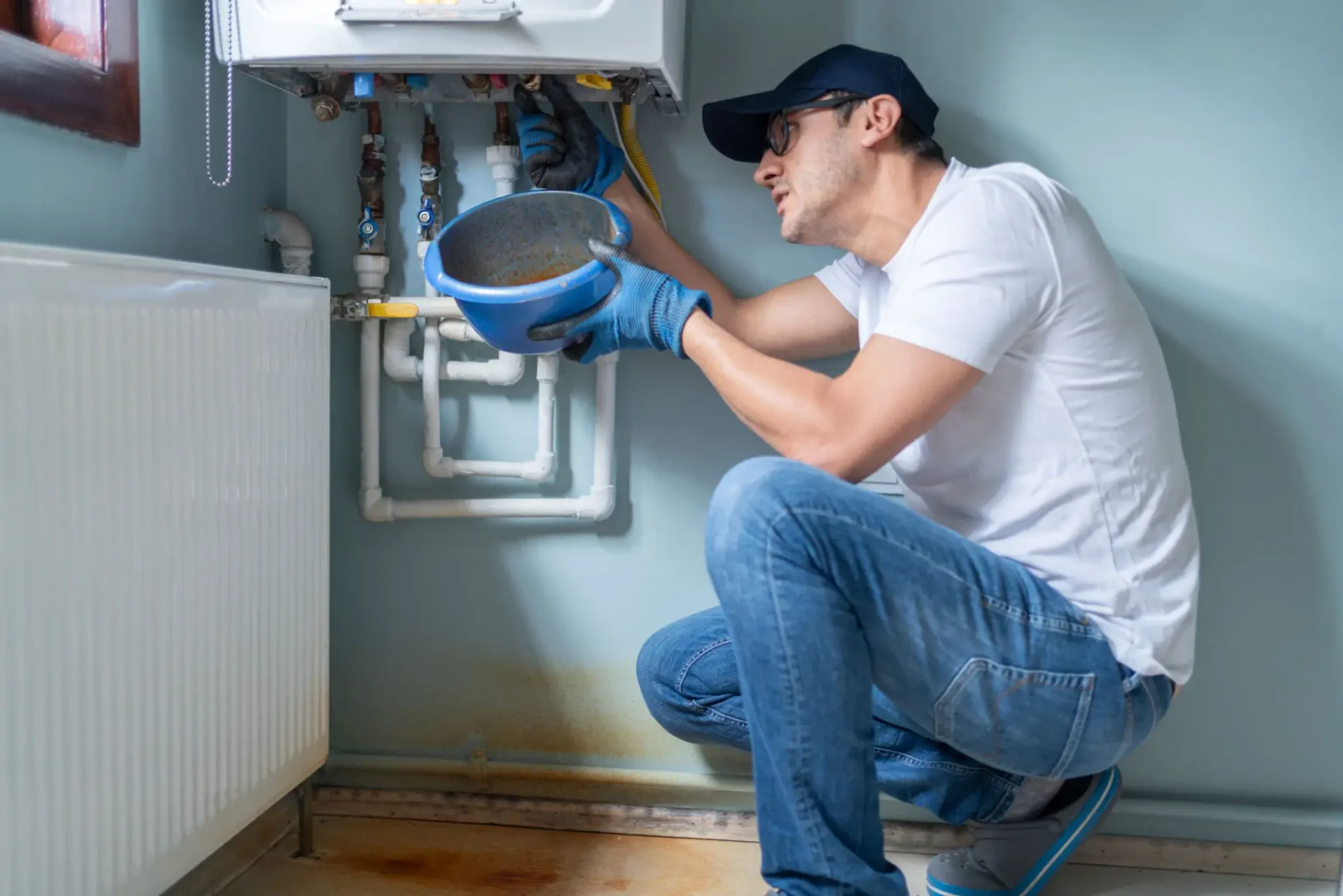 Technician inspecting home boiler with drain bowl